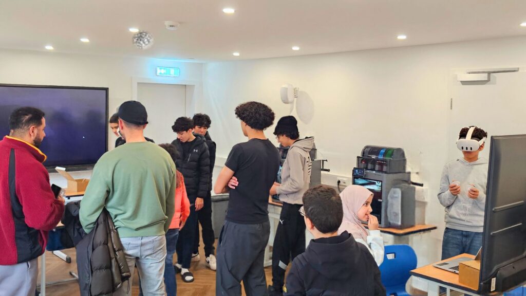 Viele Kinder und Jugendliche beim Techniktag in der TechWerkstatt Setterich, ein Jugendlicher testet eine VR-Brille